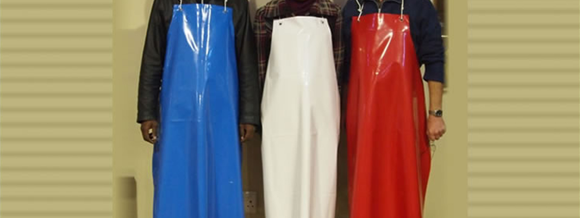 A display of three premium Kendex Tough Hygiene Workwear aprons looking pristine, durable, and clean for long-term industrial use.